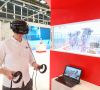 Mann mit Virtual Reality Brille vor einem Display mit virtuellen Robotern