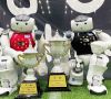 Zwei Roboter aus dem Team B-Human posieren mit den Pokalen für bestes Team im Hauptwettbewerb und im Technischen Wettbewerb.